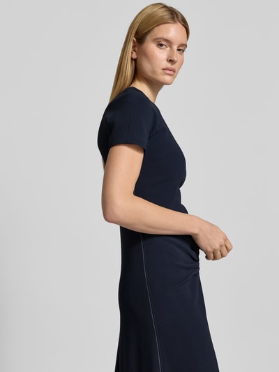 Frauenmodel trägt Midikleid aus Viskose-Mix von Victoria Beckham in Dunkelblau mit Raffungen, taillierter Passform und Rundhalsausschnitt, Nahaufnahme Oberkörper.