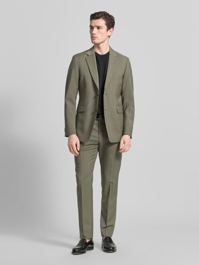 Männermodel trägt Straight Fit Stoffhose aus Reiner Wolle Modell 'Tentua' von Tiger Of Sweden in Olive, Gesäßtaschen, Ganzkörperansicht von vorne.