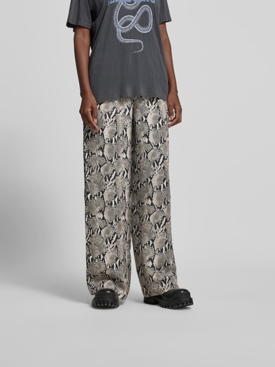 Frauenmodel trägt Stoffhose mit Viskose-Anteil von Anine Bing im Cupro-Viskose-Mix, Relaxed-Fit, elastischer Bund, gerade Beine, Schlangenprint-Muster, dezente Kontraste, fließende Textur, Bundweite 38 cm, Innenbeinlänge 84 cm, Ganzkörperansicht von vorne.