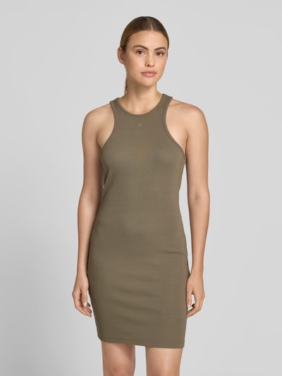 Frauenmodel trägt Slim Fit Kleid aus Viskose-Mix von Anine Bing in Olivgrün mit Logo-Stitching, Rundhalsausschnitt, Ärmelloses-Design, Ganzkörperansicht von vorne.