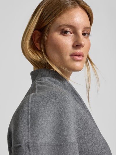 Vrouwenmodel draagt wollen jack in grijs met opstaande kraag, siernaad, los model van Style Icon Collection, detailopname, Nahaufnahme Oberkörper.