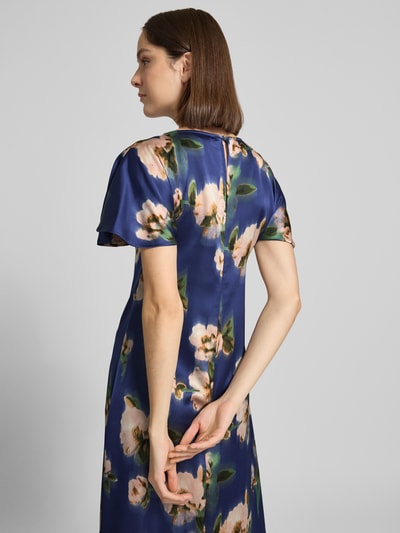 Frauenmodel trägt Cocktailkleid in Midilänge Modell 'Leonie' von GUIDO MARIA KRETSCHMER WOMAN aus Satin mit floralen Mustern, Ganzkörperansicht Rückansicht.