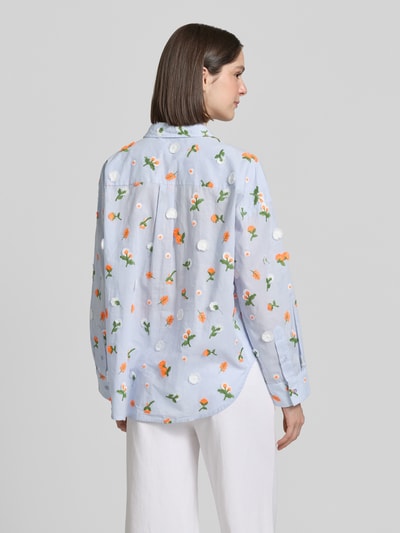 Männermodel trägt Boxy Fit Hemdbluse aus reiner Baumwolle Modell 'JIMENA' von Essentiel Antwerp mit floral-Stitching, hellblau mit bunten Applikationen, Rückenpasse mit Cacharel-Falte, lange Ärmel, Popeline-Struktur, Ganzkörperansicht Rückansicht.
