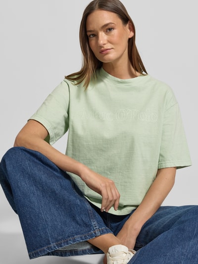 Frauenmodel trägt Boxy Fit T-Shirt aus reiner Baumwolle von Marc O'Polo, unifarben, Rundhals, Label-Schriftzug, Nahaufnahme Oberkörper.