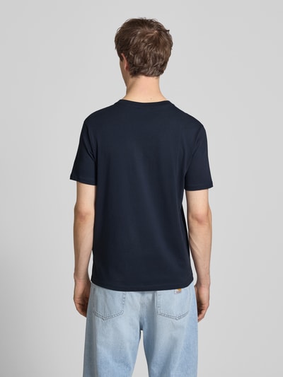 Männermodel trägt T-Shirt mit Logo und Rundhalsausschnitt von CHAMPION, Herren T-Shirt aus Reine Baumwolle, Regular-Fit, Rückenlänge 61 cm, Ganzkörperansicht Rückansicht.