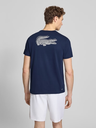 Männermodel trägt Regular Fit T-Shirt aus Baumwoll-Mix von Lacoste Sport in Dunkelblau mit Logo-Patch, Ganzkörperansicht Rückansicht.