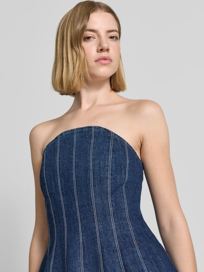 Frauenmodel trägt Regular Fit Jeansbluse aus reiner Baumwolle Modell 'FIRMA' von MAX&Co., blaue Denim-Optik, sichtbare Nähte, Twill-Material, ohne Kragen, Reißverschluss, Kurzarm, Ganzkörperansicht von vorne.