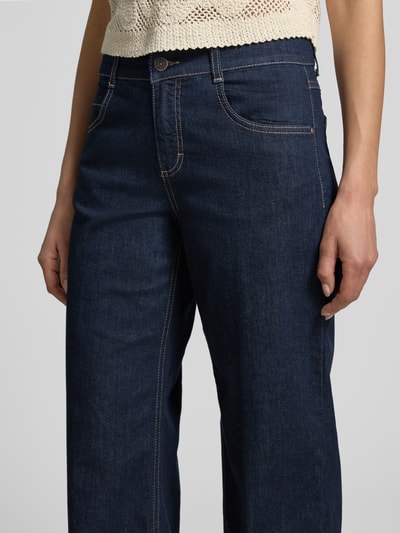 Frauenmodel trägt Jeans in verkürzter Passform Modell 'Laia' von Angels aus dunkelblauem Baumwoll-Mix mit Stretch-Anteil, Nahaufnahme Oberkörper. Kontext: Damen Jeans, Eingrifftaschen, Bundweite bei Größe 36 38 cm, Innenbeinlänge bei Größe 36 68 cm.