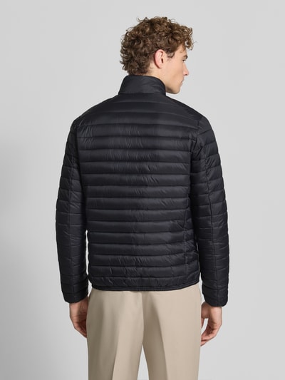 Männermodel trägt gewatteerd jack Model 'ALEXANDER' van Save The Duck in zwart met opstaande kraag, ruglengte maat M 67 cm, schouderbreedte 47 cm, borstwijdte 57 cm, mouwlengte 68 cm, ritszakken, slim fit, tweewegritssluiting. Ganzkörperansicht Rückansicht.