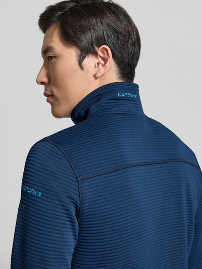 Männermodel trägt Regular Fit Fleecejacke mit Stehkragen Modell 'Berthold' von Icepeak in Dunkelblau mit elastischen Abschlüssen, Ganzkörperansicht Rückansicht.
