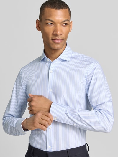 Männermodel trägt Slim Fit Businesshemd mit extra langem Arm Modell 'H-HANK-SP-C1' von Seidensticker, Optik: Allover-Muster, Ganzkörperansicht von vorne.