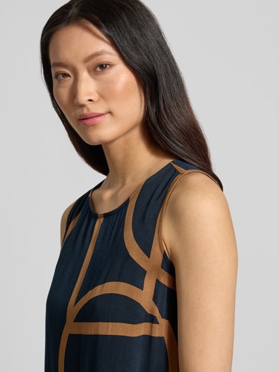 Modelka nosi Ausgestelltes Freizeitkleid aus reiner Viskose Modell 'Wicy atelier' od OPUS, ciemnoniebieski z brązowymi geometrycznymi wzorami, tekstura gładka, widok z przodu, zbliżenie na górną część ciała, sukienki casualowe