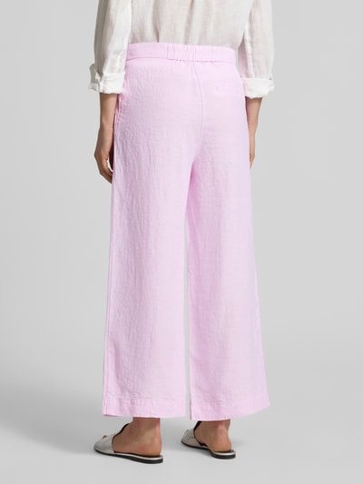 Frauenmodel trägt Leinenhose mit Bindegürtel von Christian Berg Woman in zartem Rosa, Wide Leg, reine Leinen, Knopfverschluss, Ganzkörperansicht Rückansicht.