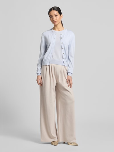 Frauenmodel trägt Cardigan aus Lyocell-Mix mit Rundhalsausschnitt Modell 'ARABELLA' von GUIDO MARIA KRETSCHMER WOMAN, Regular-Fit, pastellblau, glatte Struktur, dezente Knopfleiste, kombiniert mit weiter beigefarbener Hose, Ganzkörperansicht von vorne.