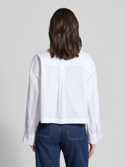 Frauenmodel trägt Oversized Hemdbluse aus reiner Bio-Baumwolle Modell 'Astha' von Selected Femme in Weiß, glatte Webware, Ganzkörperansicht Rückansicht.