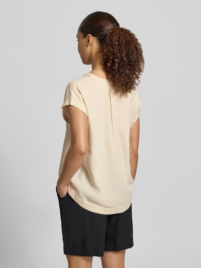 Männermodel trägt Blusenshirt aus mieszanka lnu i wiskozy Modell 'INA' von Soyaconcept w kolorze jasny beż, prosty krój, dekolt w serek, krótkie rękawy, długość tyłu w rozmiarze S: 61 cm, długość rękawów w rozmiarze S: 20 cm, gładka tekstura, Ganzkörperansicht Rückansicht.