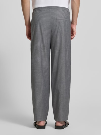 Männermodel trägt graue Herren Jog Pants mit französischen Eingrifftaschen Modell 'YROWAY' von American Vintage, Material-Mix mit Viskose-Anteil, Straight Fit, elastischer Bund, Gesäßleistentasche, feine Streifenstruktur, Ganzkörperansicht Rückansicht.