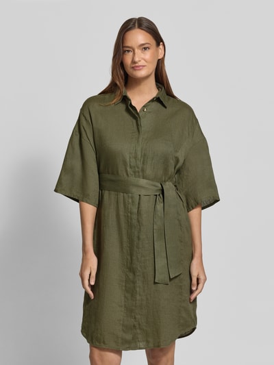 Modelka kobieca ma na sobie Regular Fit Leinenkleid aus reinen Leinen Modell 'Derby' od 0039 Italy w kolorze oliwkowym, półprzezroczysty materiał, taliowany krój, rękaw o dł. 1/2, wykładany kołnierz, listwa guzikowa, odpinana materiałowa tasiemka, długość tyłu w rozmiarze S: 96 cm, szerokość w rozmiarze S: 59 cm, długość rękawów w rozmiarze S: 24 cm; widok na całą sylwetkę z przodu.