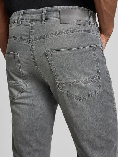 Männermodel trägt Regular Fit Jeans aus Baumwoll-Mix Modell 'Arne Pipe' von MAC, grauer Denim, 5-Pocket-Design, Rückansicht, Detailaufnahme.
