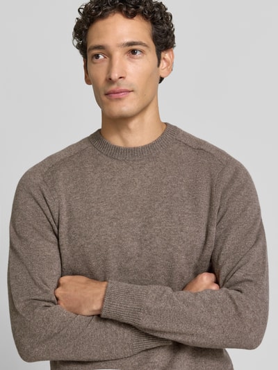 Männermodel trägt Regular Fit Strickpullover aus reinem Kaschmir von FTC Cashmere in Braun mit gerippten Abschlüssen, Nahaufnahme Oberkörper.