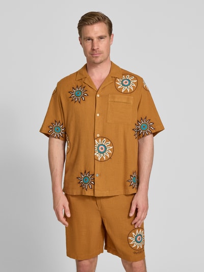 Männermodel trägt Relaxed Fit Freizeithemd aus Leinen-Viskose-Mix mit Brusttasche von Scotch & Soda, florales Allover-Stitching, Reverskragen, Kurzärmelig, Knopfleiste, Ganzkörperansicht von vorne.