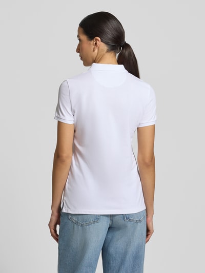 Frauenmodel trägt Slim Fit Poloshirt mit Knopfleiste von Christian Berg Woman aus Baumwoll-Elasthan-Mix in Weiß, Seitenschlitze, Rückenlänge 62 cm bei Größe S, Ganzkörperansicht Rückansicht.