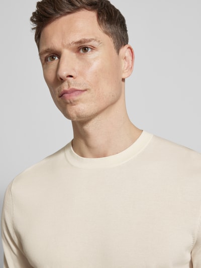 Männermodel trägt Slim Fit T-Shirt aus reiner Baumwolle von Profuomo in Creme mit Rundhalsausschnitt, Nahaufnahme Oberkörper.