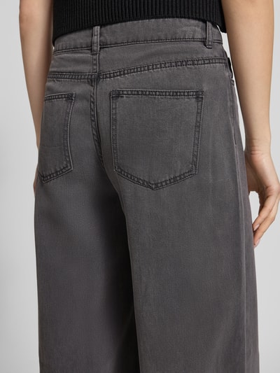 Männermodel trägt Wide Leg Jeans aus Lyocell-Mix Modell 'SMIDI' von Pieces, szary denim, 5-kieszeniowy, z szlufkami, detaliczny widok tyłu.