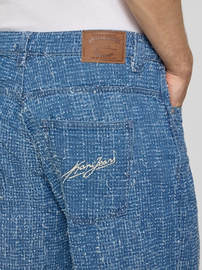 Männermodel trägt Jeansshorts mit Strukturmuster und Eingrifftaschen von Karl Kani, Reine Baumwolle, Regular-Fit, Detailaufnahme Rückansicht.
