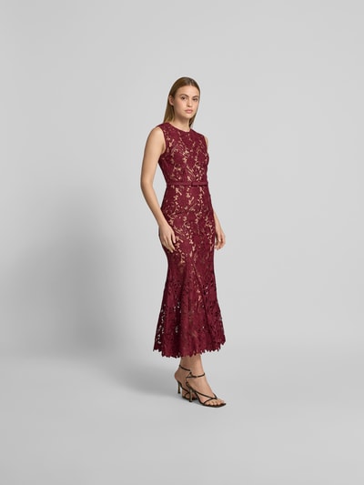 Vrouwenmodel draagt Maxikleid aus floraler Spitze van Self-Portrait in bordeauxrood, elastische materiaalmix, slim fit, bloemenkant, afneembare tailleband, mouwloos design, totale lengte maat S 137 cm, borstwijdte 40 cm, taillewijdte 34 cm, geheellichaamsaanzicht van voren.