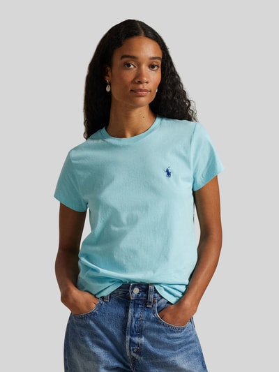 Modelka nosi T-shirt mit Label-Stitching od Polo Ralph Lauren, damski t-shirt z bawełny, krój regular fit, jasno niebieski, wyhaftowane logo, okrągły dekolt, długość tyłu w rozmiarze S: 54 cm, zbliżenie na górną część sylwetki, widok z przodu.