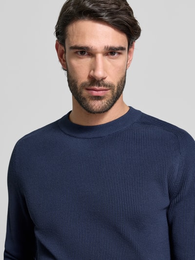 Männermodel trägt Slim Fit Pullover in Strick-Optik Modell 'Nordin' von Casual Friday in Dunkelblau, reine Baumwolle, Nahaufnahme Oberkörper.