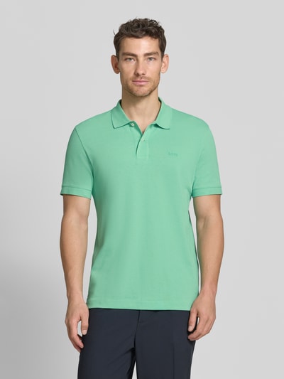 Männermodel trägt Regular Fit Poloshirt aus reiner Baumwolle Modell 'PALLAS' von BOSS, Optik: Unifarben, Piqué, Nahaufnahme Oberkörper.