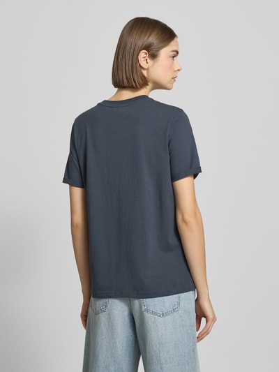 Vrouwenmodel draagt Regular Fit T-Shirt uit pure katoen model 'RIA' van Pieces, effen donkerblauw, fijnrib, korte mouw, rugaanzicht.