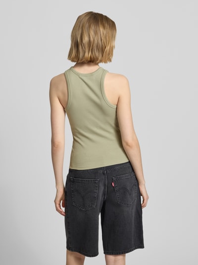 Frauenmodel trägt Tanktop mit Rundhalsausschnitt von REVIEW in Grün, Baumwoll-Elasthan-Mix, Feinripp, eng anliegende Passform, Ganzkörperansicht Rückansicht.