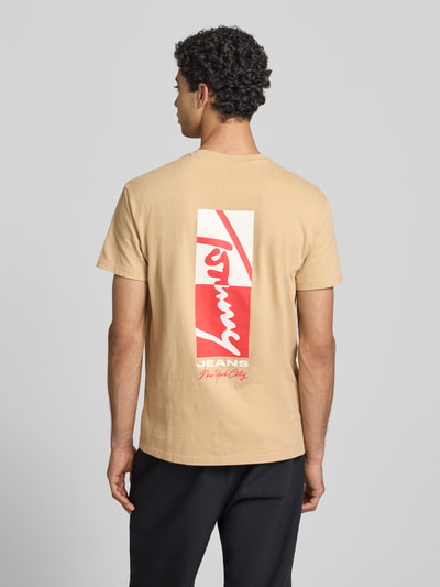 Männermodel trägt Regular Fit T-Shirt aus reiner Baumwolle von Tommy Jeans in Optik: Unifarben mit Motiv-Print, Ganzkörperansicht Rückansicht.