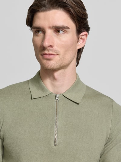 Männermodel trägt Slim Fit Pullover mit Polokragen Modell 'GUNA' von Samsøe Samsøe in hellem Grün, Nahaufnahme Oberkörper.