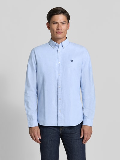Męski model nosi Regular Fit Freizeithemd aus reiner Baumwolle von MCNEAL w jasnoniebieskim kolorze, wyhaftowane logo, Kołnierzyk typu button down, Z długim rękawem, Długość tyłu w rozmiarze M: 76 cm, Szerokość w rozmiarze M: 45 cm, Długość rękawów w rozmiarze M: 66 cm, widok całej sylwetki z przodu