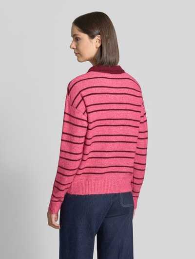 Frauenmodel trägt Strickpullover mit Woll-Anteil Modell 'SAGE' von ICHI in Pink mit dunklen Streifen und gerippten Abschlüssen, Relaxed Fit, Ganzkörperansicht Rückansicht.