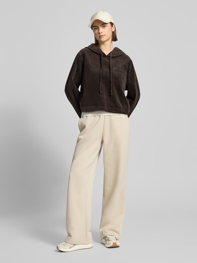 Frauenmodel trägt Oversized Hoodie aus reiner Baumwolle von Marc O'Polo Denim, Optik: Unifarben, Passform: Oversized, Struktur, Cord, Label-Stitching-Applikation, Langarm, Kapuze mit Tunnelzug, überschnittene Schultern, Materialverarbeitung: Cord, Ganzkörperansicht von vorne.