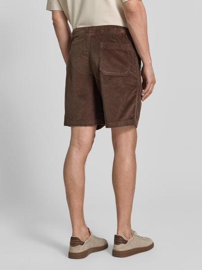 Männermodel trägt Regular Fit Sweatshorts aus Baumwoll-Mix Modell 'JACE' von SELECTED HOMME in Braun mit Cordstruktur, Gesäßtasche, Ganzkörperansicht Rückansicht.
