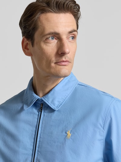 Mężczyznamodel nosi Regular Fit Blouson aus reiner Baumwolle von Polo Ralph Lauren, efekt: jednolity kolor, wykładany kołnierz, zamek błyskawiczny, detal z logo marki, długi rękaw, elastyczne zakończenie rękawów i dołu, wpuszczane kieszenie, bawełna, z przodu, zbliżenie na górną część ciała.