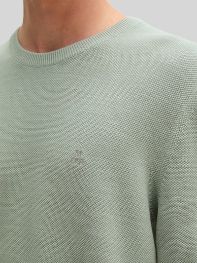 Männermodel trägt Regular Fit Pullover aus reiner Baumwolle von Marc O'Polo in hellgrün mit feiner Struktur, Nahaufnahme Oberkörper.