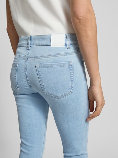 Frauenmodel trägt Slim Fit Jeans mit Stitching von Marc Cain, hellblaue Baumwoll-Mix-Denim mit Stretch, Detailaufnahme Rückansicht.