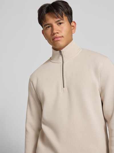 Männermodel trägt Regular Fit Sweatshirt mit Baumwoll-Anteil Modell 'Bradley' von JACK & JONES in Beige, Nahaufnahme Oberkörper, Material-Mix, Troyer-Kragen.