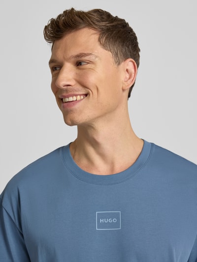 Męski model nosi Regular Fit T-Shirt aus Baumwoll-Mix Modell 'LAZE T-SHIRT' od HUGO, niebieski, krótki rękaw, nadruk z logo, bawełna, zbliżenie górnej części ciała.
