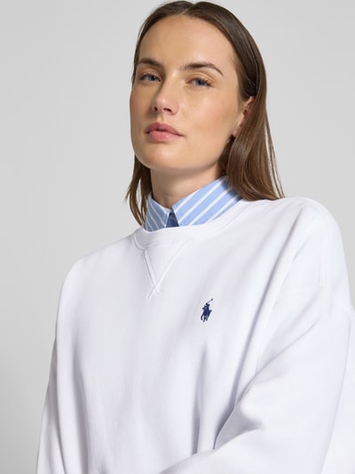 Vrouwenmodel draagt Oversized Sweatshirt aus Baumwoll-Mix van Polo Ralph Lauren, unikleurig, oversized fit, logo detail, ronde hals, lange mouwen, geribde boorden, sweatstof, katoenmix, close-up bovenlichaam.