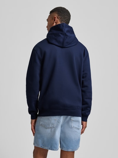 Männermodel trägt Hoodie mit Logo und Känguru-Tasche von GAP in Dunkelblau, Baumwoll-Mix, Regular Fit, Ganzkörperansicht Rückansicht.
