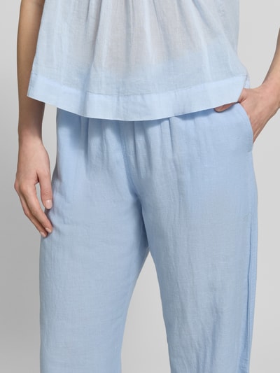 Frauenmodel trägt Stoffhose mit Leinen-Anteil und Eingrifftaschen von Neo Noir in Hellblau, Baumwoll-Mix, entspannter Schnitt, Nahaufnahme Oberkörper.