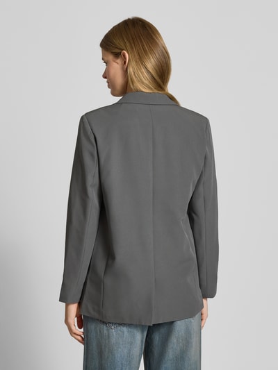 Frauenmodel trägt Blazer mit Reverskragen Modell 'Bossy' von PIECES in Grau, Materialmischung mit Stretch-Anteil, lockerer Schnitt, Ganzkörperansicht Rückansicht.